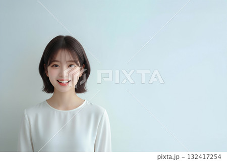 白い背景で爽やかに笑顔を見せる若い女性 132417254