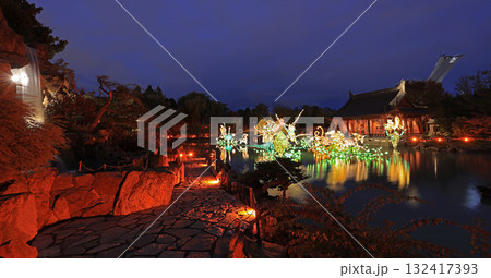 Chinese Garden illuminated at night with colorful figurines reflected on water, Chinese Pavilion and Stadium tower Chinese Garden illuminated at night with colorful figurines reflected on water, Chinese Pavilion and Stadium tower 132417393