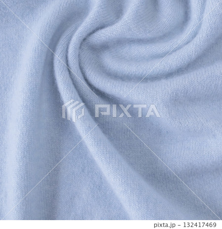Blue cashmere fabric, textile is folded, knitwear texture, natural fabric, top view. Soft light blue fabric texture with soft folds. 132417469