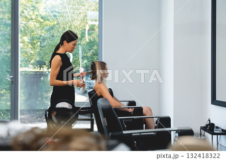 A skilled makeup artist carefully applies foundation on the model face in a modern beauty salon 132418322