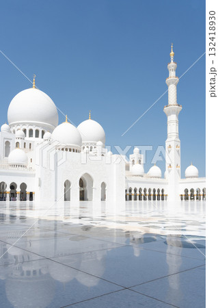 Vertical shot of beautiful white marble mosque with shiny square in foreground, United Arab Emirates Vertical shot of beautiful white marble mosque with shiny square in foreground, United Arab Emirates 132418930