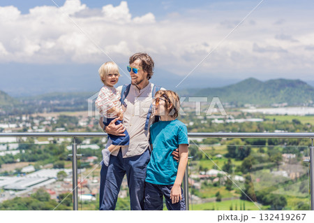 Father with his two sons standing in front of Popocatepetl volcano in Mexico, surrounded by clouds, enjoying a scenic family adventure and breathtaking outdoor view Father with his two sons standing in front of Popocatepetl volcano in Mexico, surrounded by clouds, enjoying a scenic family adventure and breathtaking outdoor view 132419267