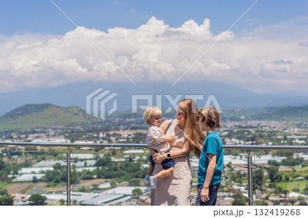 Mother with his two sons standing in front of Popocatepetl volcano in Mexico, surrounded by clouds, enjoying a scenic family adventure and breathtaking outdoor view Mother with his two sons standing in front of Popocatepetl volcano in Mexico, surrounded by clouds, enjoying a scenic family adventure and breathtaking outdoor view 132419268