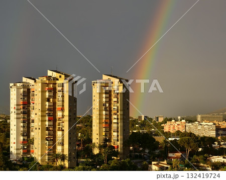 rainbow hues adorn sleek skyscrapers, stylish towers reflect warm colors against stormy urban sky 132419724