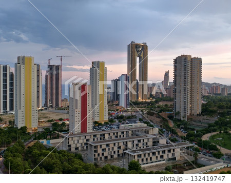 soft evening light over urban development, city skyline with ongoing construction under sunset glow 132419747