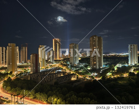 night skyline with illuminated towers, nighttime cityscape featuring bright beams and glowing night skyline with illuminated towers, nighttime cityscape featuring bright beams and glowing 132419761