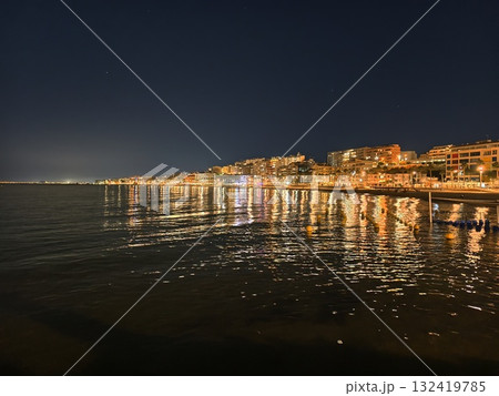 calm harbor lights glow softly, serene harbor illuminated at midnight with gentle ripples and warm 132419785