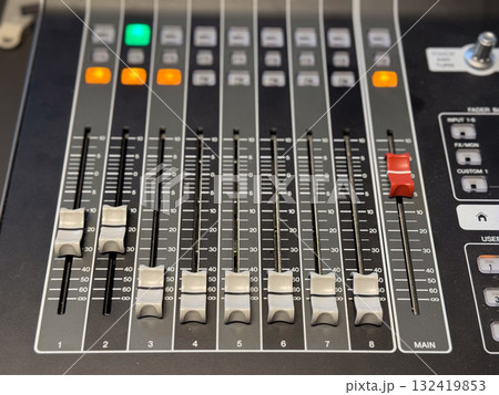 Audio mixing console with sliders and illuminated buttons. Sound engineering, music production and professional recording technology for creative audio control. 132419853