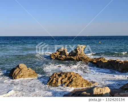 romantic seaside scene, warm sunset lighting on coast, golden evening light over calm ocean waves 132420134