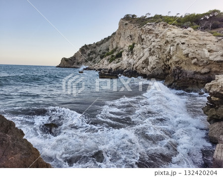 coastal scenery with rocks and surf, spectacular rocky coast with crashing waves and photographer 132420204