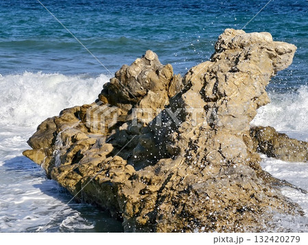 wild ocean display, fierce surf over rocks, powerful waves crash against jagged formations 132420279