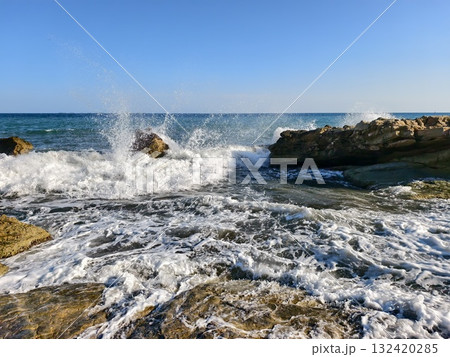 sea wave explosion, vivid image of wave hitting rocks, dynamic sea spray and foam in dramatic scene 132420285