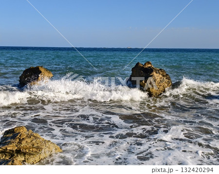 mossy boulders in turquoise ocean surf, pair of mosscovered stones sitting in shallow blue water 132420294