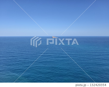 tiny isolated island amidst peaceful blue ocean and expansive clear sky inspiring solitude tiny isolated island amidst peaceful blue ocean and expansive clear sky inspiring solitude 132420354