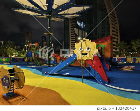 vibrant playground scene, urban playground with cheerful sun sculpture and tranquil evening ambiance 132420417
