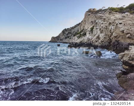 calm sea with rocky shoreline, peaceful coastal landscape with gentle ripples and warm sunlight calm sea with rocky shoreline, peaceful coastal landscape with gentle ripples and warm sunlight 132420514