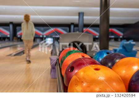 Bowler aiming for a strike in a modern bowling alley during an evening outing with friends 132420594