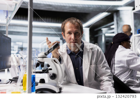 Scientist attends online video call in research lab to present discovery in chemistry and biotechnology. Teleconference with healthcare data, molecular biology and advanced research results. 132420793