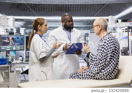 Team of scientists conducting clinical research and testing on a patient to evaluate new drug effects, monitoring vitals. People study reactions, progress in healthcare development. 132420899