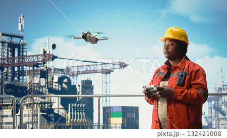 Woman on offshore platform deck doing site inspections using automated drone system. Drilling rig ship worker using aerial photography technology to determine optimal locations for pipelines, 132421008