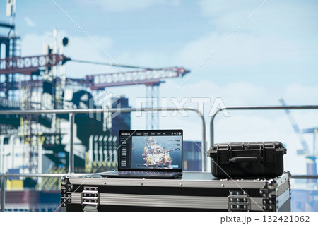 Laptop on drilling rig ship with software dashboard used for anomaly detection during operation. Notebook on offshore platform deck with program used to control systems remotely 132421062