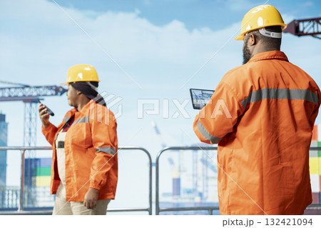 Offshore platform expert tracking oil production efficiency using tablet app. Drilling rig coworkers use device program to check equipment sensor readings, doing maintenance Offshore platform expert tracking oil production efficiency using tablet app. Drilling rig coworkers use device program to check equipment sensor readings, doing maintenance 132421094
