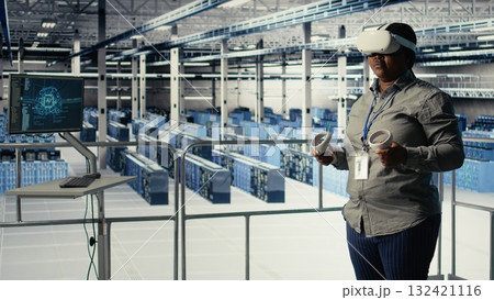 Data center IT expert investigates AI configurations using virtual reality, making adjustments for optimal function. Server hub engineer checks artificial intelligence error using VR headset, camera A 132421116