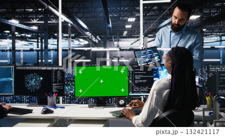 Female programmer talking with manager in data center, reviews AI diagnostics on green screen PC. IT expert and supervisor optimizes artificial intelligence systems using mockup computer, camera A Female programmer talking with manager in data center, reviews AI diagnostics on green screen PC. IT expert and supervisor optimizes artificial intelligence systems using mockup computer, camera A 132421117