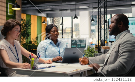 African american candidate signing employment contract during interview with HR manager and assistant, filling the new organization position after the selection process. Hiring a person. Camera A. 132421118