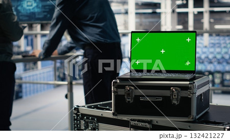 Close up of isolated screen laptop in front of data center programmers improving AI rigs processing speed. Server hub coworkers manage gear using chroma key device to support AI workloads, camera B Close up of isolated screen laptop in front of data center programmers improving AI rigs processing speed. Server hub coworkers manage gear using chroma key device to support AI workloads, camera B 132421227