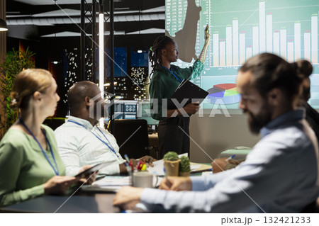 Chief financial officer presenting capital funds and revenue data on annual reports in conference room, reviewing profit increase and budget allocation for new project. After hours late meeting. 132421233