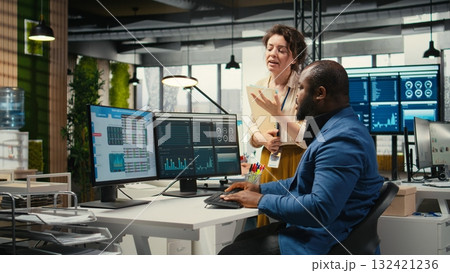 Multiethnic work team consulting each other in completing monthly reports, reviewing KPI data insights for business productivity. Collaboration between employees for success. 132421236