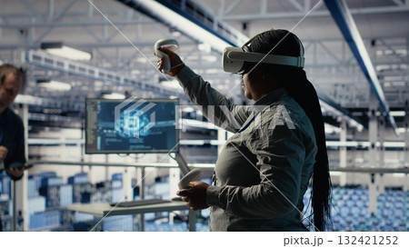 Data center system administrators deploy machine learning software on infrastructure racks. Team of server hub IT experts train AI systems with datasets using tablet to support applications, camera B 132421252