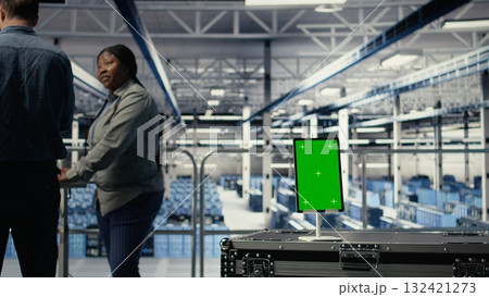 Data center workers monitor AI processes with isolated screen tablet, reviewing metrics. Engineers use chroma key device to review artificial intelligence reports during inspection, camera A Data center workers monitor AI processes with isolated screen tablet, reviewing metrics. Engineers use chroma key device to review artificial intelligence reports during inspection, camera A 132421273