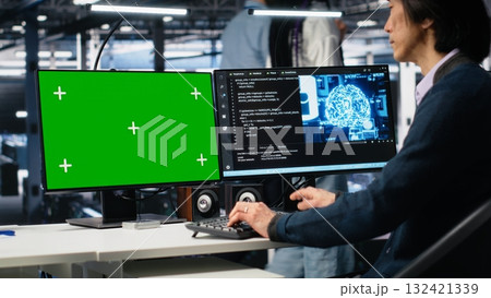 Data center technician uses machine learning algorithms on isolated screen PC to analyze datasets. Server hub worker uses AI neural networks on chroma key computer to recognize data patterns, camera A 132421339