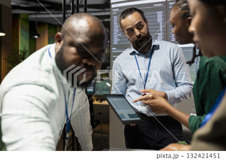 Diverse coworkers team engaging in after hours collaboration during meeting, reviewing statistics and projections while sharing files and providing feedback on finance objectives. Business intel. 132421451