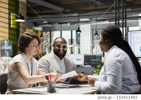 Human resources team conduct CV evaluation with candidate during job interview in a business space, analyzing work experience and qualifications for career development. Talent acquisition. 132421465