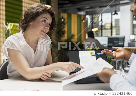 Candidate and HR manager going over job position benefits during formal meeting, discuss employment package as wellness programs, monthly salary, rights and annual compensation details. Candidate and HR manager going over job position benefits during formal meeting, discuss employment package as wellness programs, monthly salary, rights and annual compensation details. 132421466