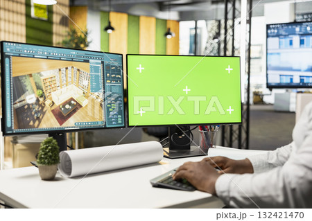 Male developer decorating apartment layout on 3D software next to green screen display, working with interior design tools for residential decorations project. Real estate management. Male developer decorating apartment layout on 3D software next to green screen display, working with interior design tools for residential decorations project. Real estate management. 132421470