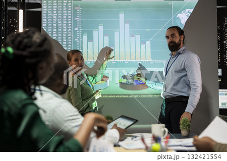 Management team sharing insight on statistics in night corporation meeting, providing initiatives to enhance operational performance metrics. Group of business associates in boardroom. 132421554