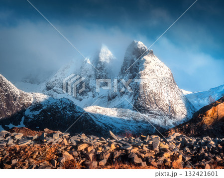 Snow-capped mountain peaks in low clouds at sunrise in winter Snow-capped mountain peaks in low clouds at sunrise in winter 132421601
