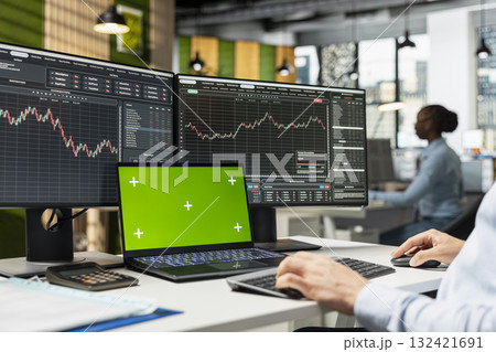 Risk analyst monitors live market activity on isolated screen laptop to identify market volatility signs. Employee reviewing portfolio performance reports on mockup notebook device Risk analyst monitors live market activity on isolated screen laptop to identify market volatility signs. Employee reviewing portfolio performance reports on mockup notebook device 132421691