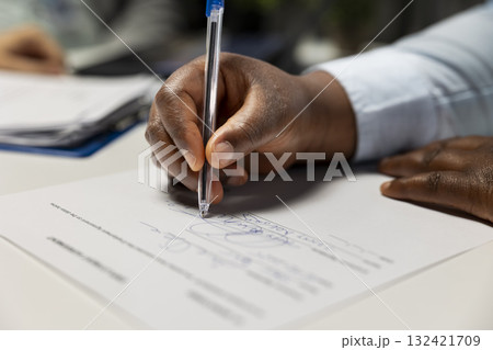 Close up of black candidate signing legal contract paper during HR meeting, beginning the hiring process and onboarding journey. Exciting multinational company job position. Career growth. 132421709