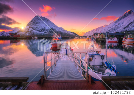 Fishing boats in harbor at sunset with snowy mountains at sunset Fishing boats in harbor at sunset with snowy mountains at sunset 132421758