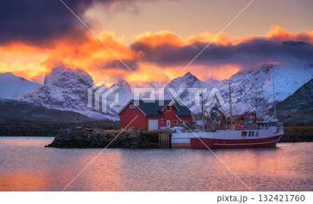 Red fishing boats on the sea, snowy mountains at colorful sunset 132421760