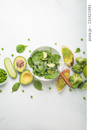 Fresh salad bowl, avocado toasts, raw green vegetables fruit white background top view, diet, vegetarian healthy food 132421991