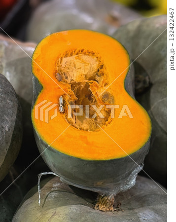Close-up of halved pumpkin showing vibrant orange flesh and seeds, autumn harvest season. Concept of Thanksgiving food, organic produce and healthy seasonal eating 132422467