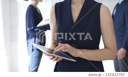 Businesswoman using digital tablet during corporate meeting, collaborating with colleagues in a modern office, planning strategies for project development and success Businesswoman using digital tablet during corporate meeting, collaborating with colleagues in a modern office, planning strategies for project development and success 132422707