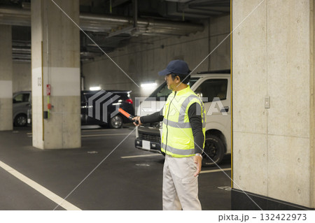 地下駐車場で誘導する男性　 132422973