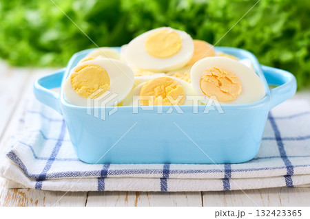 Boiled eggs in a bowl on a light kitchen table, selective focus. 132423365
